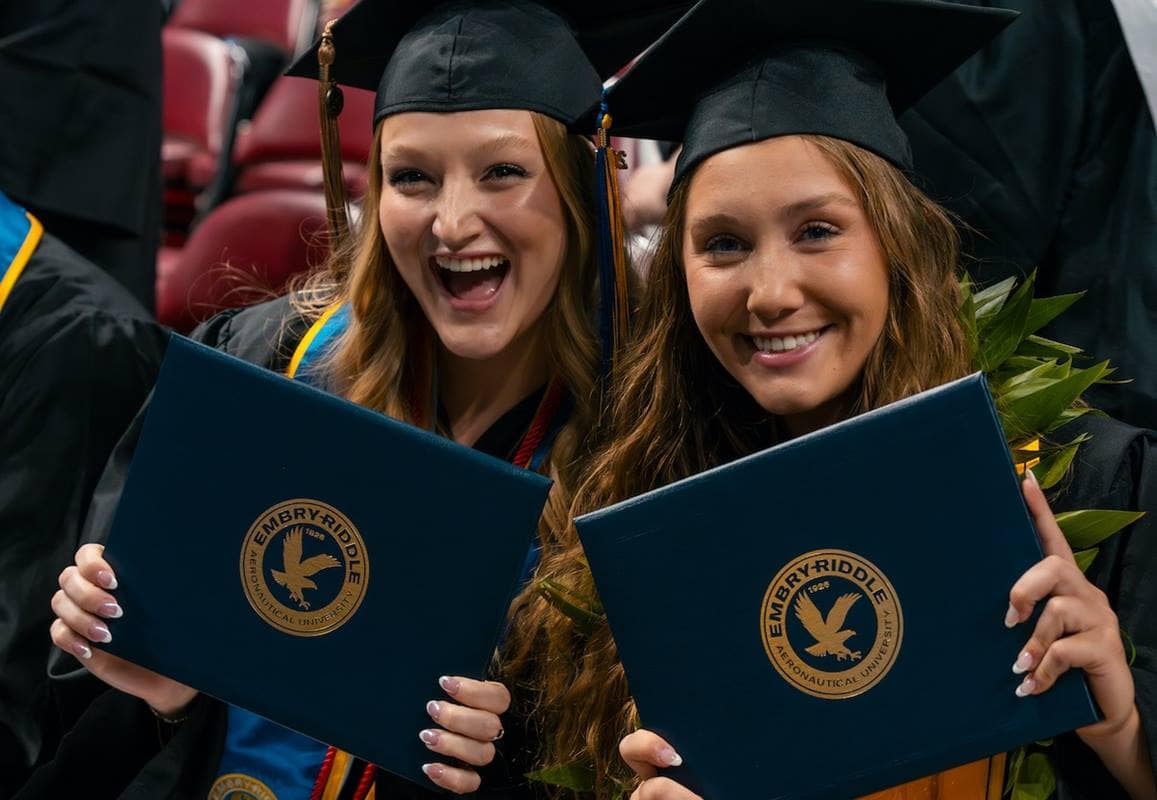 Women graduates pose with their diplomas