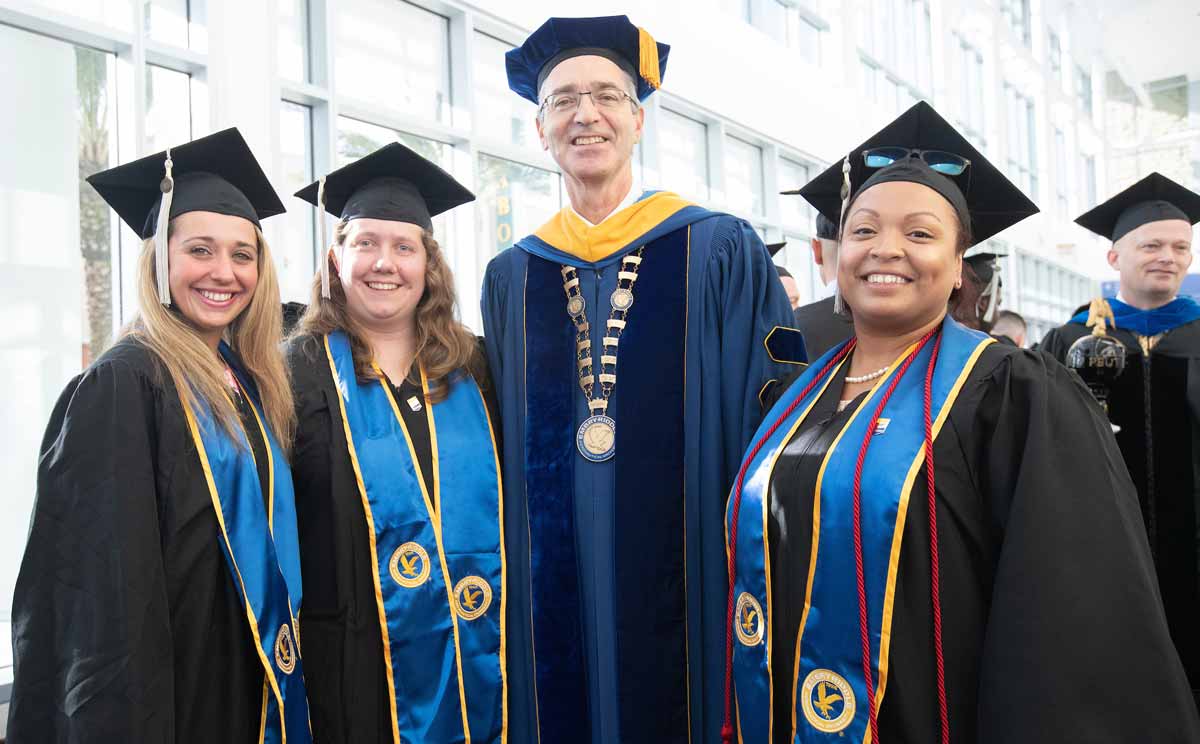 President Dr. P. Barry Butler poses for a photo with students before the graduation ceremony for the Embry-Riddle graduating class of fall 2018 at the Ocean Center in Daytona Beach.