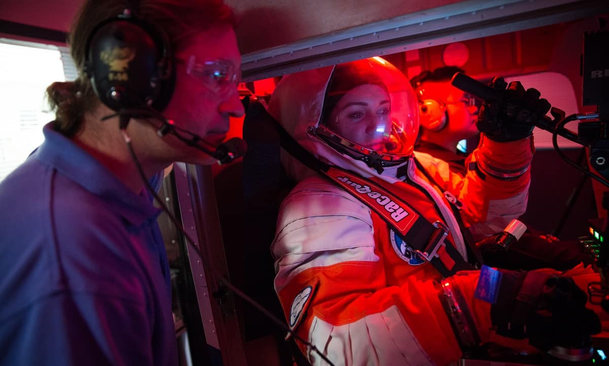 Project PoSSUM Executive Director Jason Reimuller works with student Rachel Weeks in the space-flight simulator. 