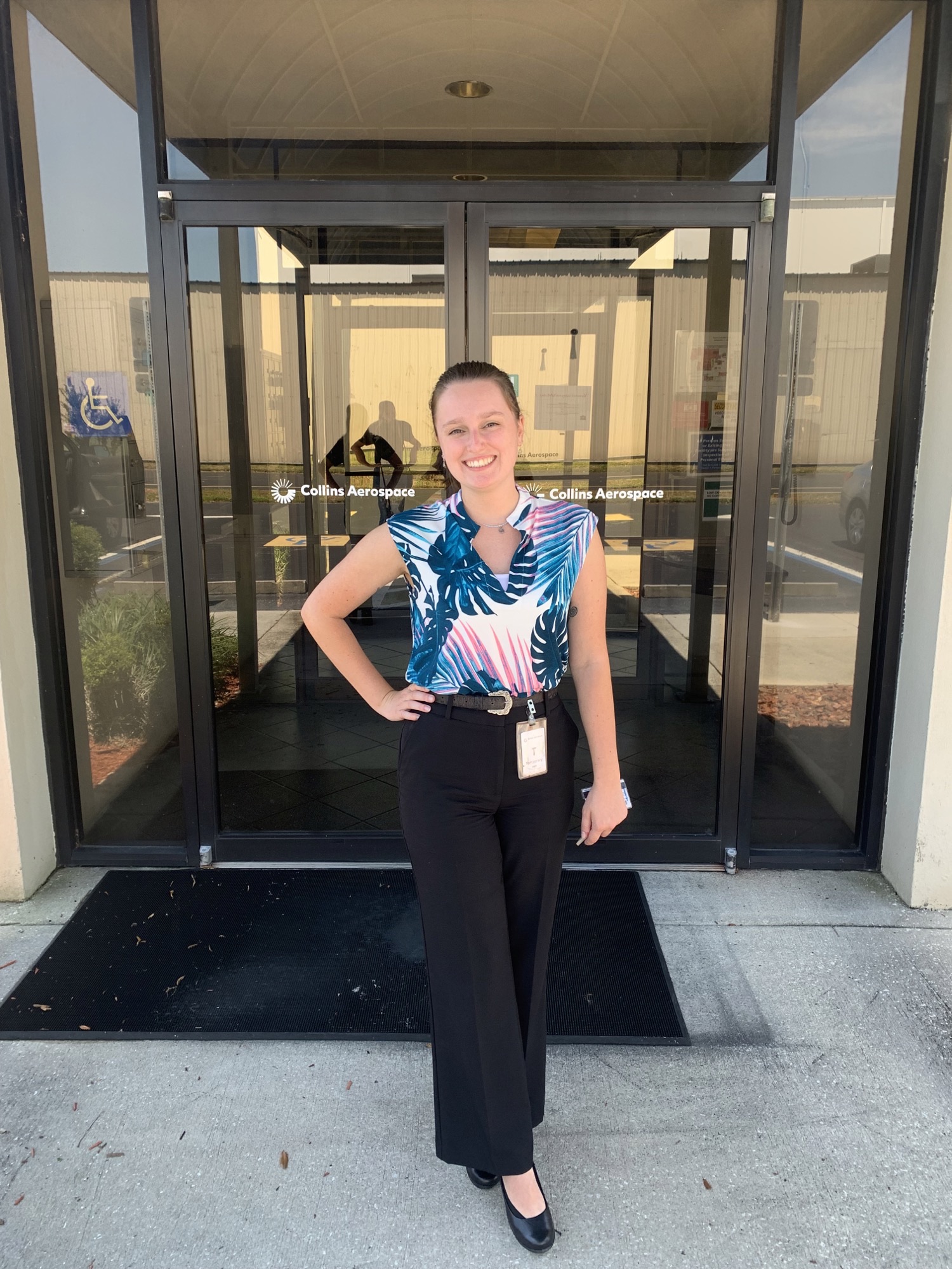 Leah Smith standing in front of double doors that say Collins Aerospace