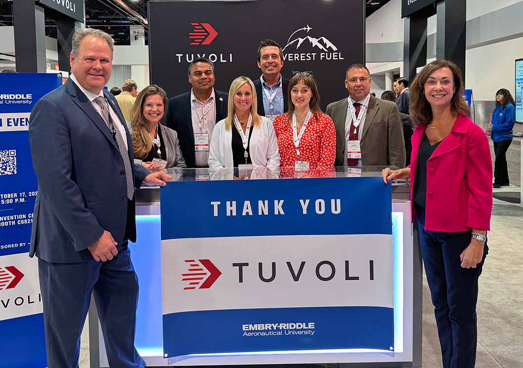 Greg Johnson, president and CEO of Tuvoli, holds thank you sign with Dean Shanan Gibson with other standing behind sign.