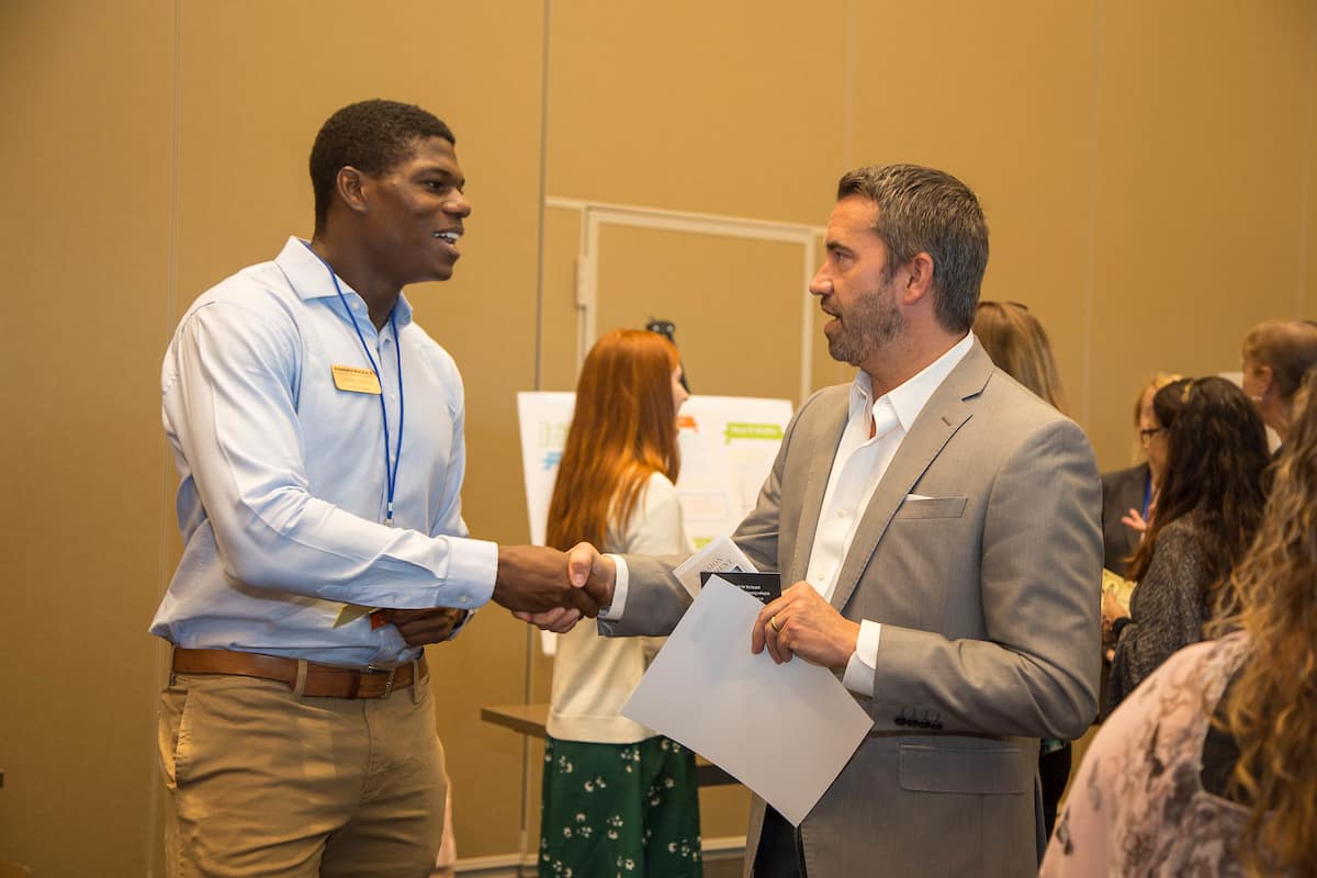 Embry-Riddle student Lonnie Marts discusses his venture concept with Scott Ambrose, assistant professor of marketing, at the TREP Expo on November 15.