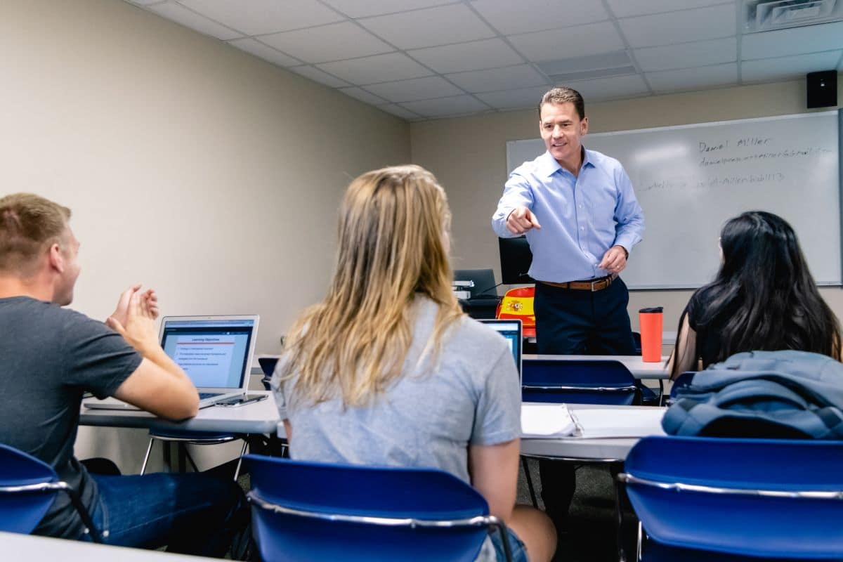 Dr. Thomas Drape, Director of Prescott's School of Business, engages students in a classroom discussion about business