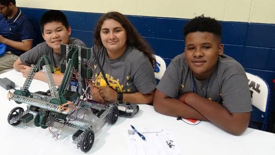 Walker Middle School students Kevin Nguyen, Yeali Irizarry and Lonnie Brailsford-Colon prepare their robot for competition. (Photo by Alan Marcos Pinto Cesar.)