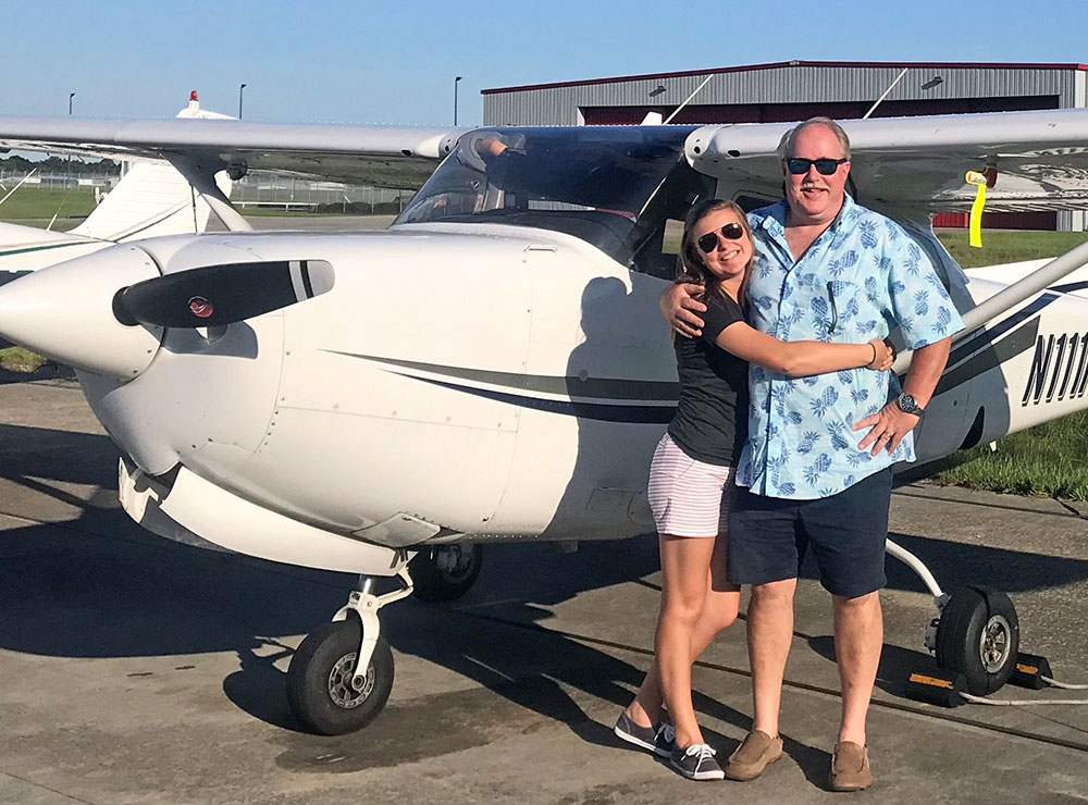 Kiristan and dad in front of small single-engine plane