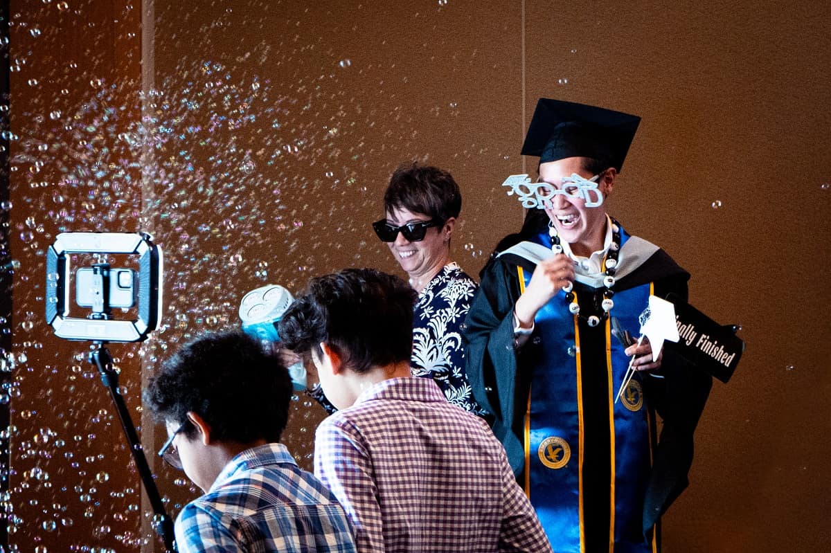 A Worldwide graduate blows bubbles.