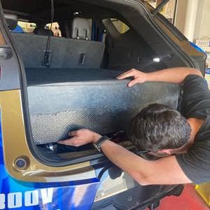 Student works on trunk of EcoCar.