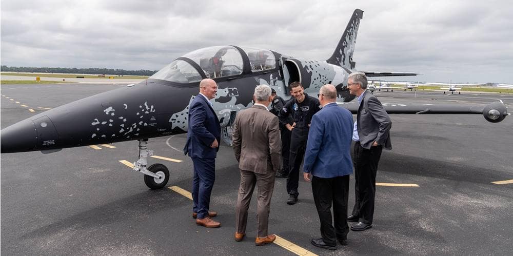 Men stand by a fighter jet.