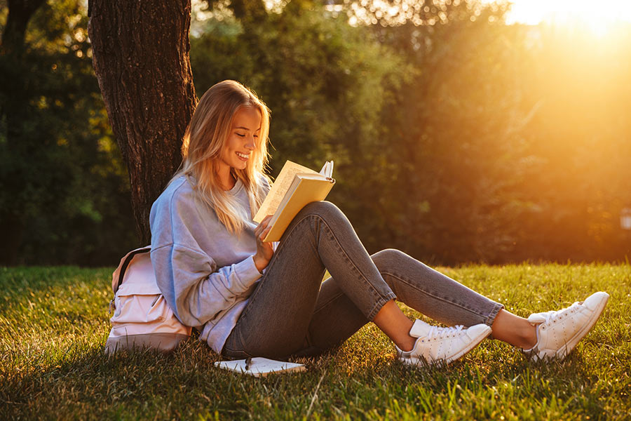 Female student sitting outside reading