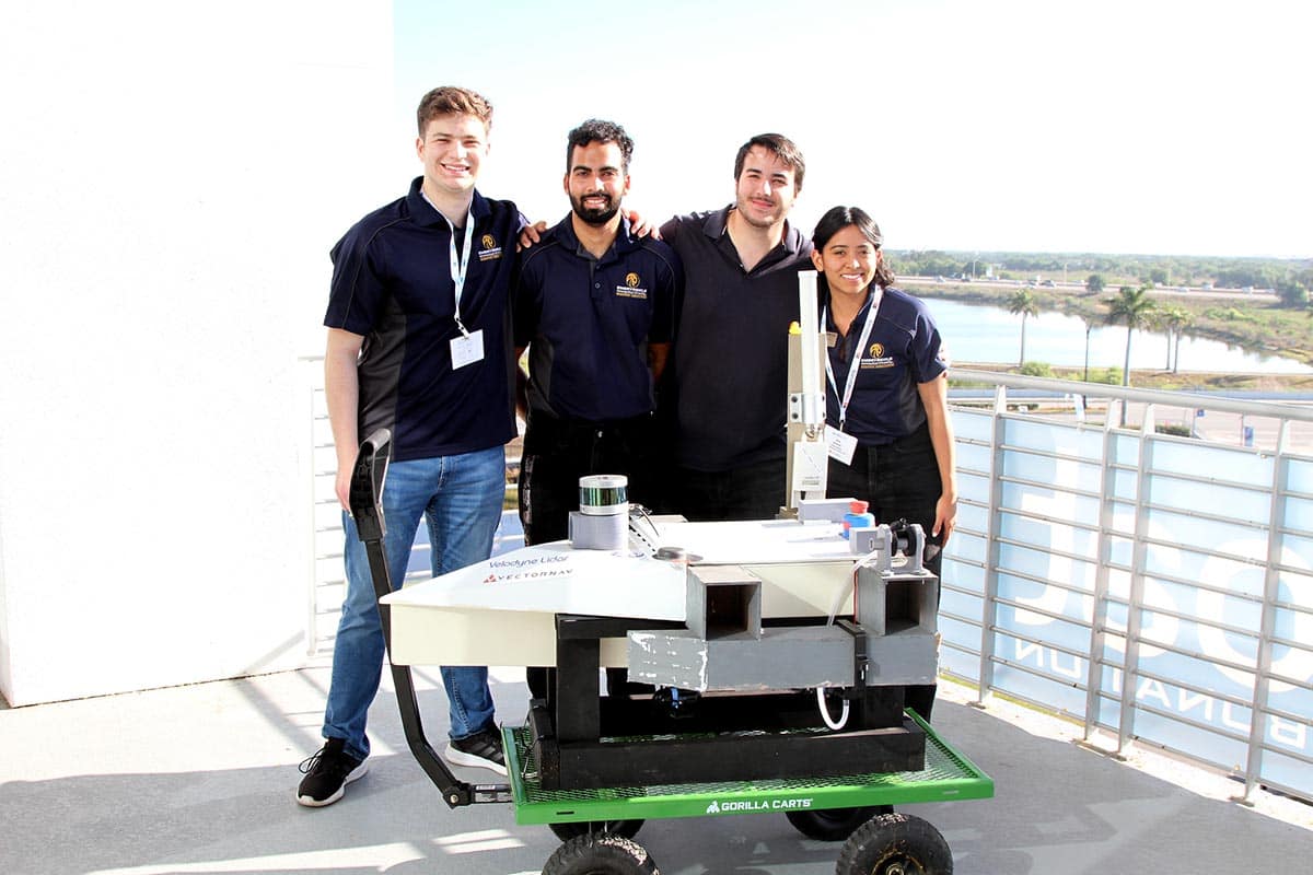 Embry-Riddle students Francisco Bustamante, Dominic Marsh, Alejandro Kassarjian and Ana Alvarez pose with the team’s autonomous boat, Phantom 2