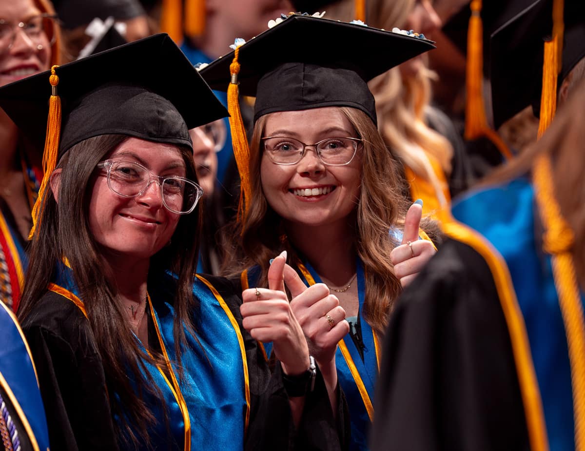 Students give thumbs up at Prescott graduation.