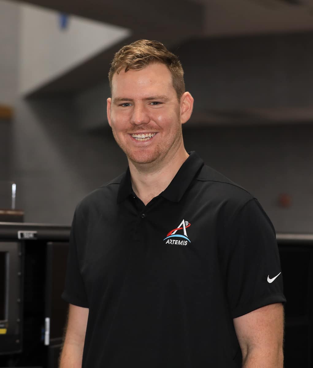 Man with brown hair in black polo