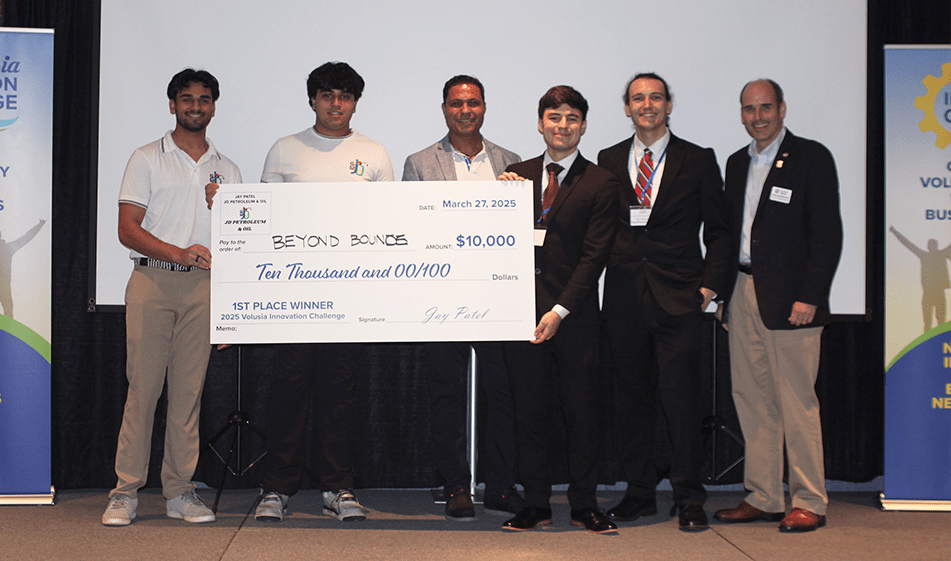 Six people hold giant check for 10,000 dollars