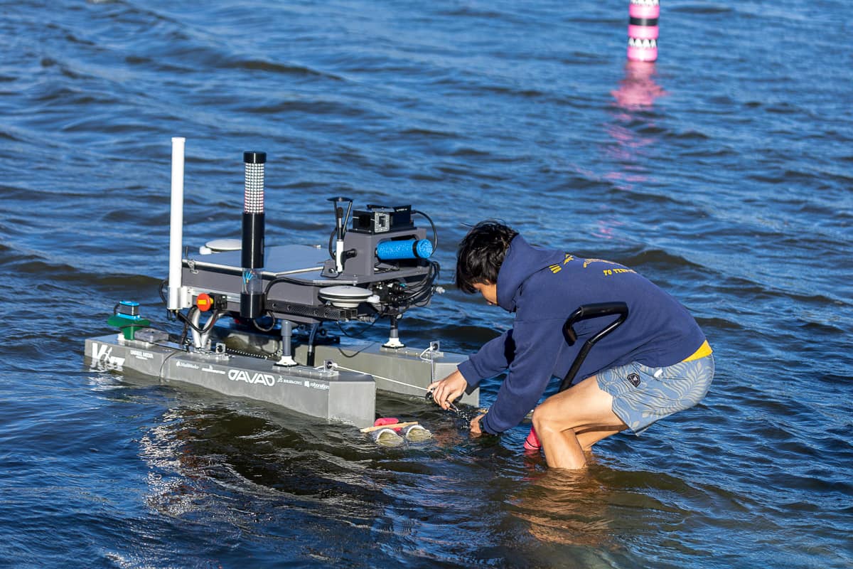 Man in water releasing robotic boat