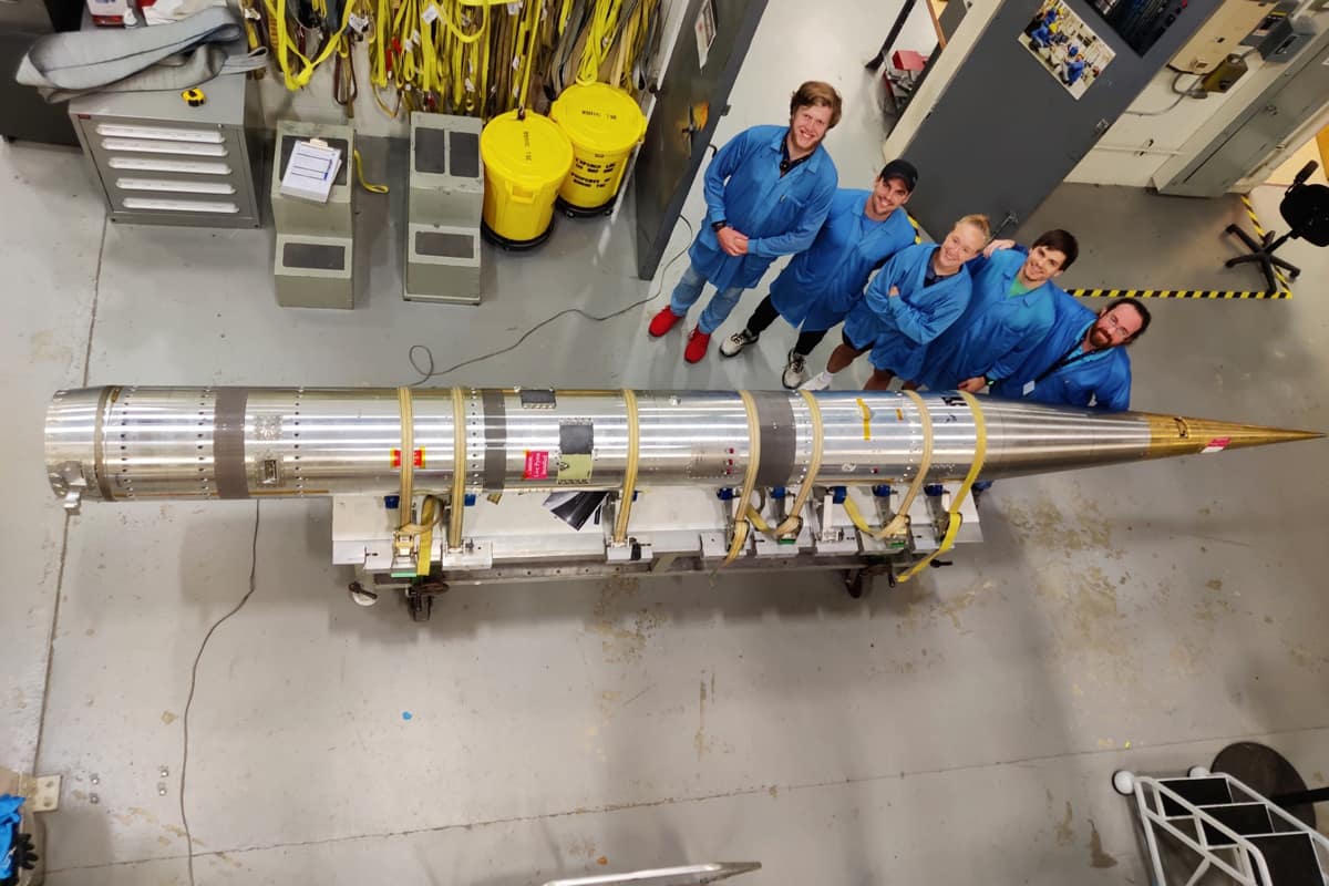 Students stand next to the Speed Demon rocket