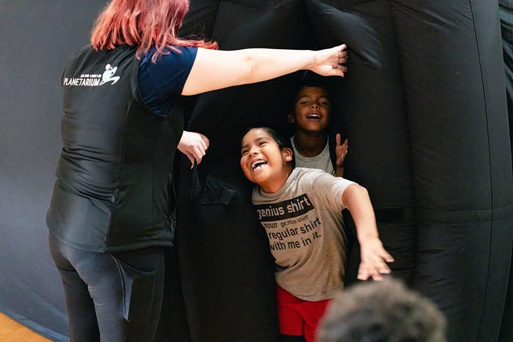 Students from the Yavapai Apache Nation in Camp Verde emerge from the Jim and Linda Lee Planetarium mobile dome