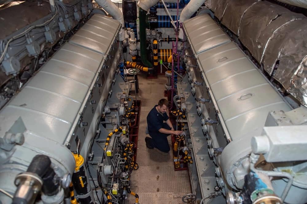 A U.S. Navy sailor inspects an engineering space aboard the Nimitz-class aircraft carrier USS Theodore Roosevelt