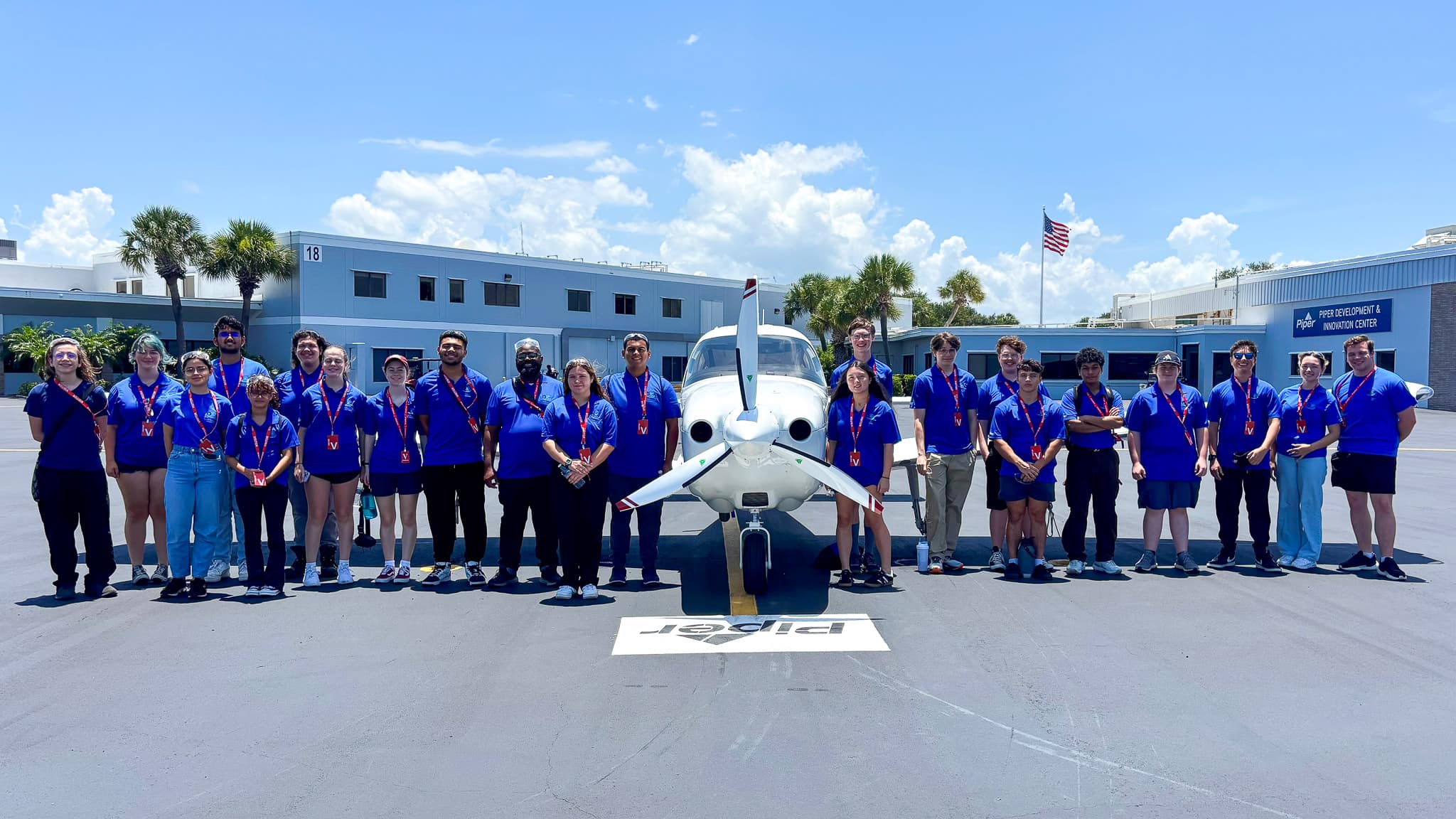 A group of people standing next to a white airplane.