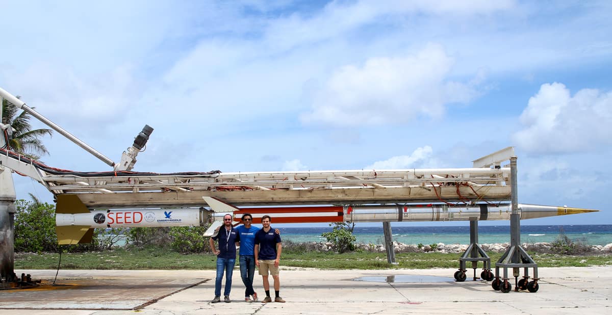Dr. Robert Clayton, Dr. Aroh Barjatya, and Nathan Graves in front of one of the SEED rockets mounted on the launch rail.