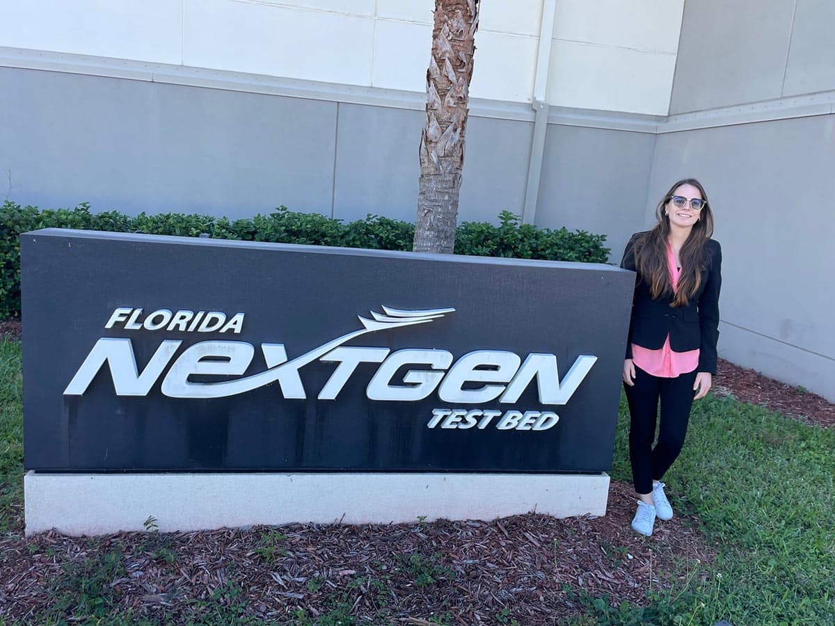 Carly Bosma poses next to the NextGen sign