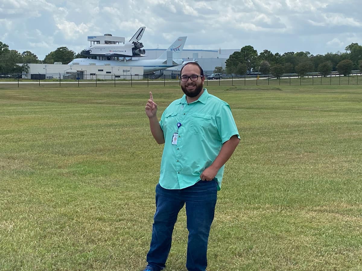 Ryan Diaz, who now works at NASA Johnson Space Center, stands in front of the shuttle transport plane mockup at Space Center Houston.
