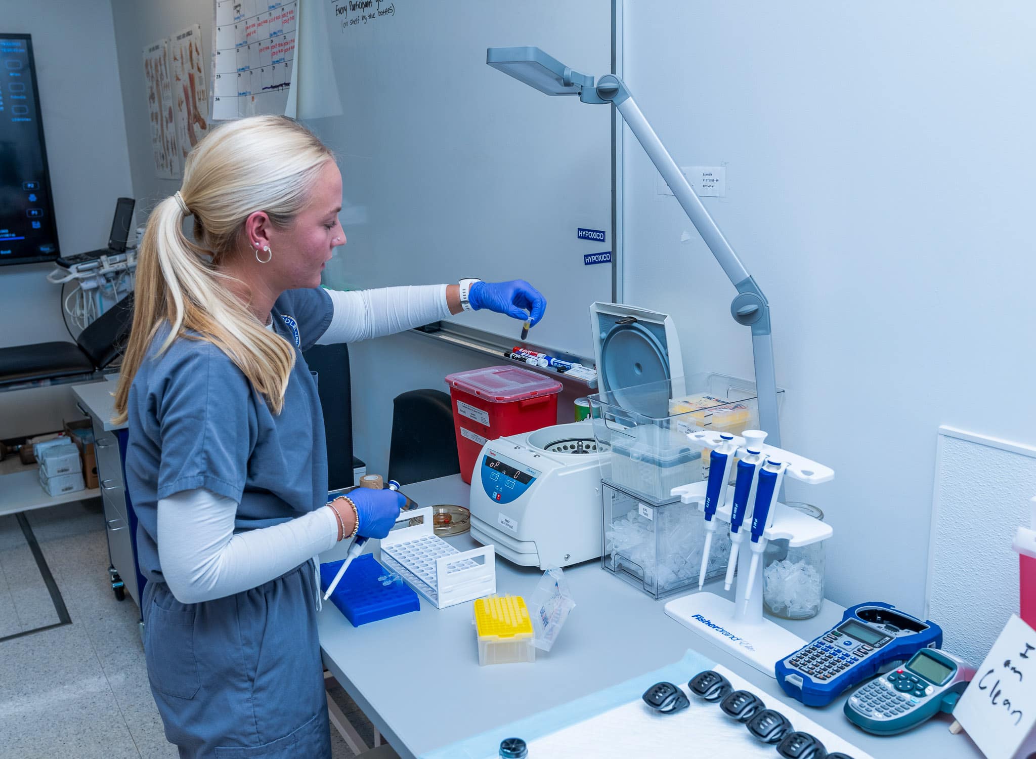 Erica Bryant, a senior in Aerospace Physiology, removes a blood sample from the centrifuge and prepares to separate blood plasma from the rest of the cells. She will be measuring the concentration of nitrate and nitrite in the blood to assess if the nitrate supplement (beet juice) increased those values as anticipated.