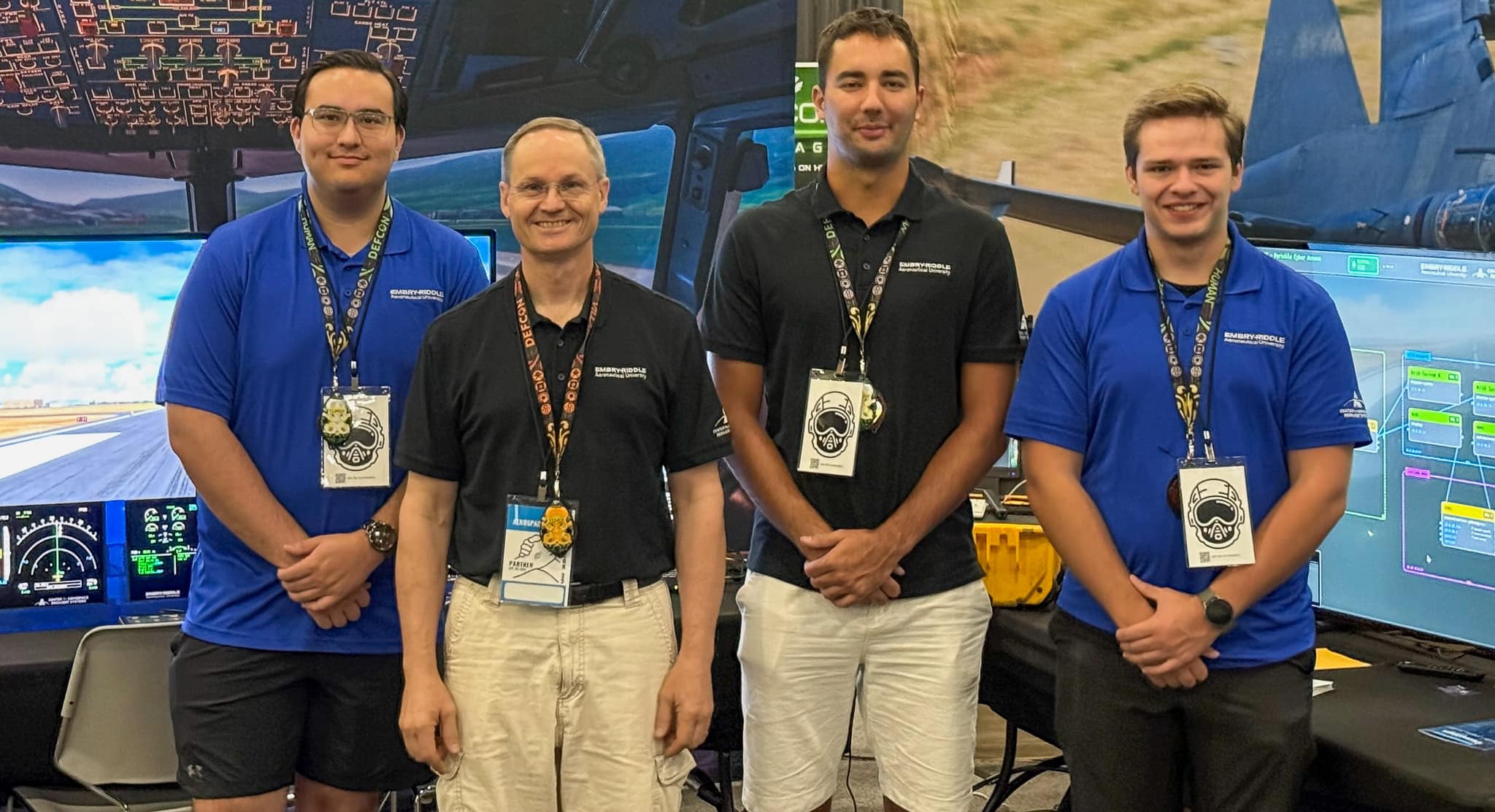 Intern Payton Macias, CARS executive director Dan Diessner, intern Samuil Nikolov and intern Sean McConoughey brought a flight simulator that could run mock cybersecurity attacks to the Aerospace Village at DEF CON.