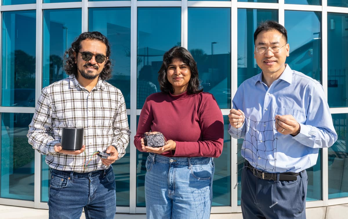 Embry-Riddle’s Dr. Morad Nazari, graduate student Sahasra Boyapati and Dr. Daewon Kim (from right to left) display prototype components of their space debris removal system.