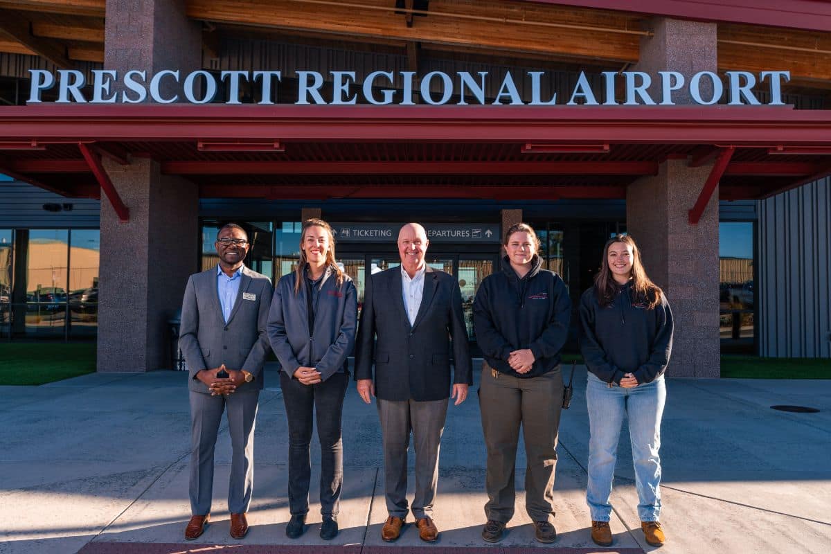 Department Chair and Associate Professor of Air Transport Economics Dr. Jules Yimga (left) reunites with three former students who now work at the Prescott airport. Here, they are alongside him and Airport Director Rick Crider, A.A.E (center).