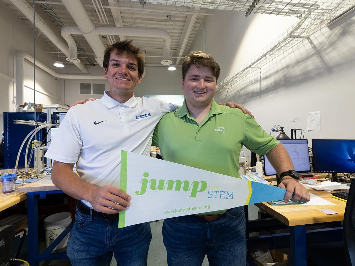 Embry-Riddle engineering students Spencer Marinac and Jared Williams pose with a JUMP Into STEM pennant