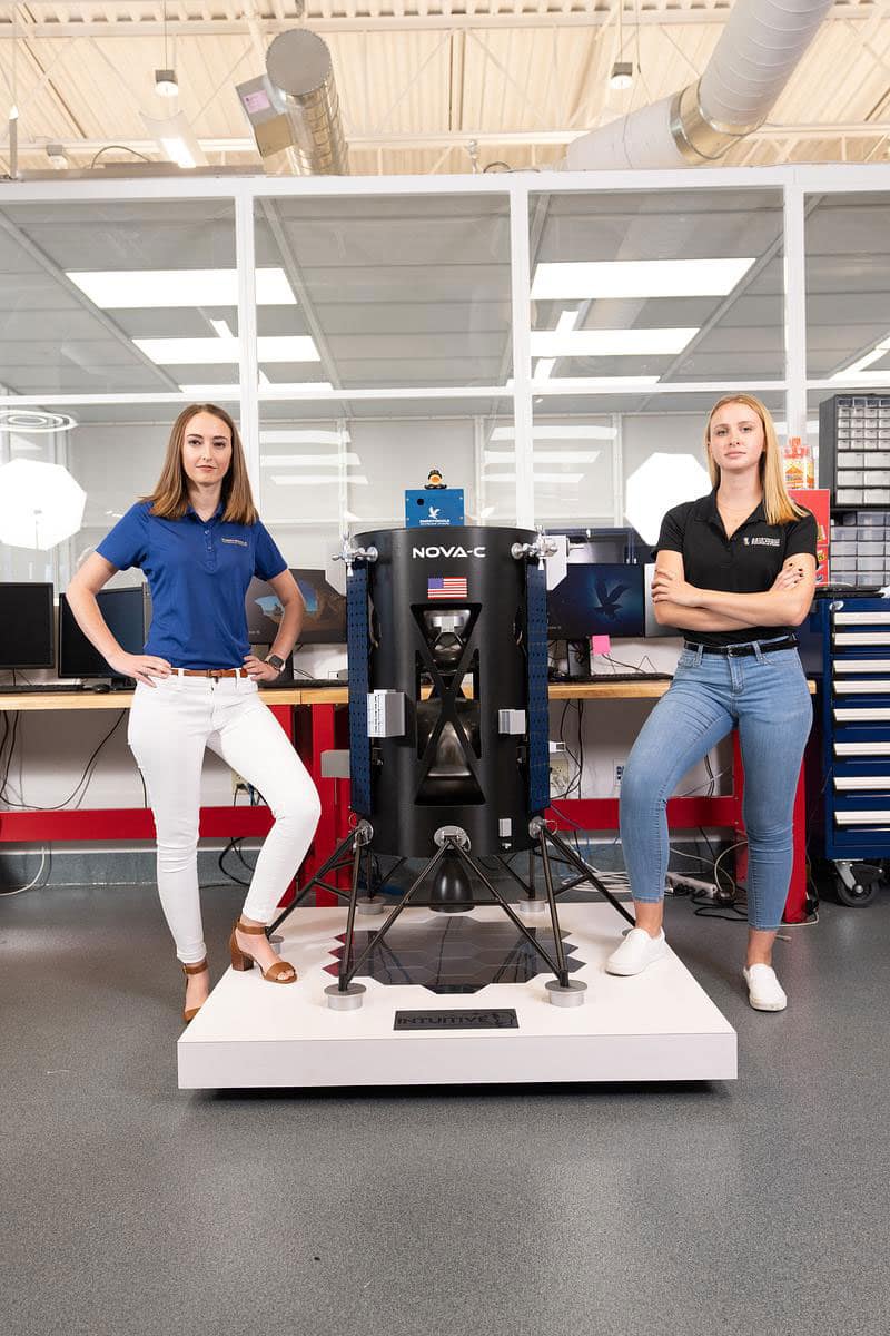 EagleCam team members Taylor Yow and Grace Robertson stand next to a one-third replica model of Intuitive Machines’ Odysseus Nova-C class Lunar Lander. Robertson, who graduated in 2022, now works as a systems engineer for Sierra Space.