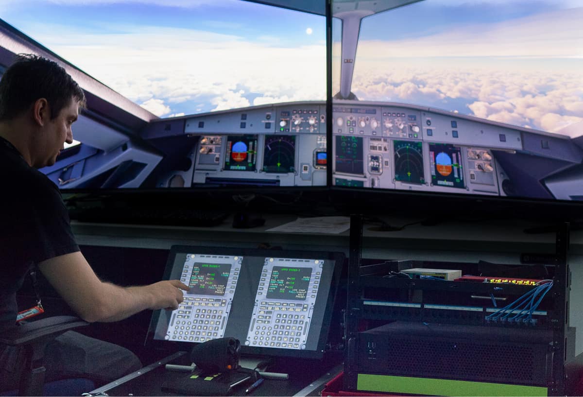Jake Neighbors, software engineer, points to a simulated flight management system computer in Embry-Riddle’s CARS lab, part of the virtual aircraft architecture being developed by CARS for the FAA to enhance aviation cybersecurity.