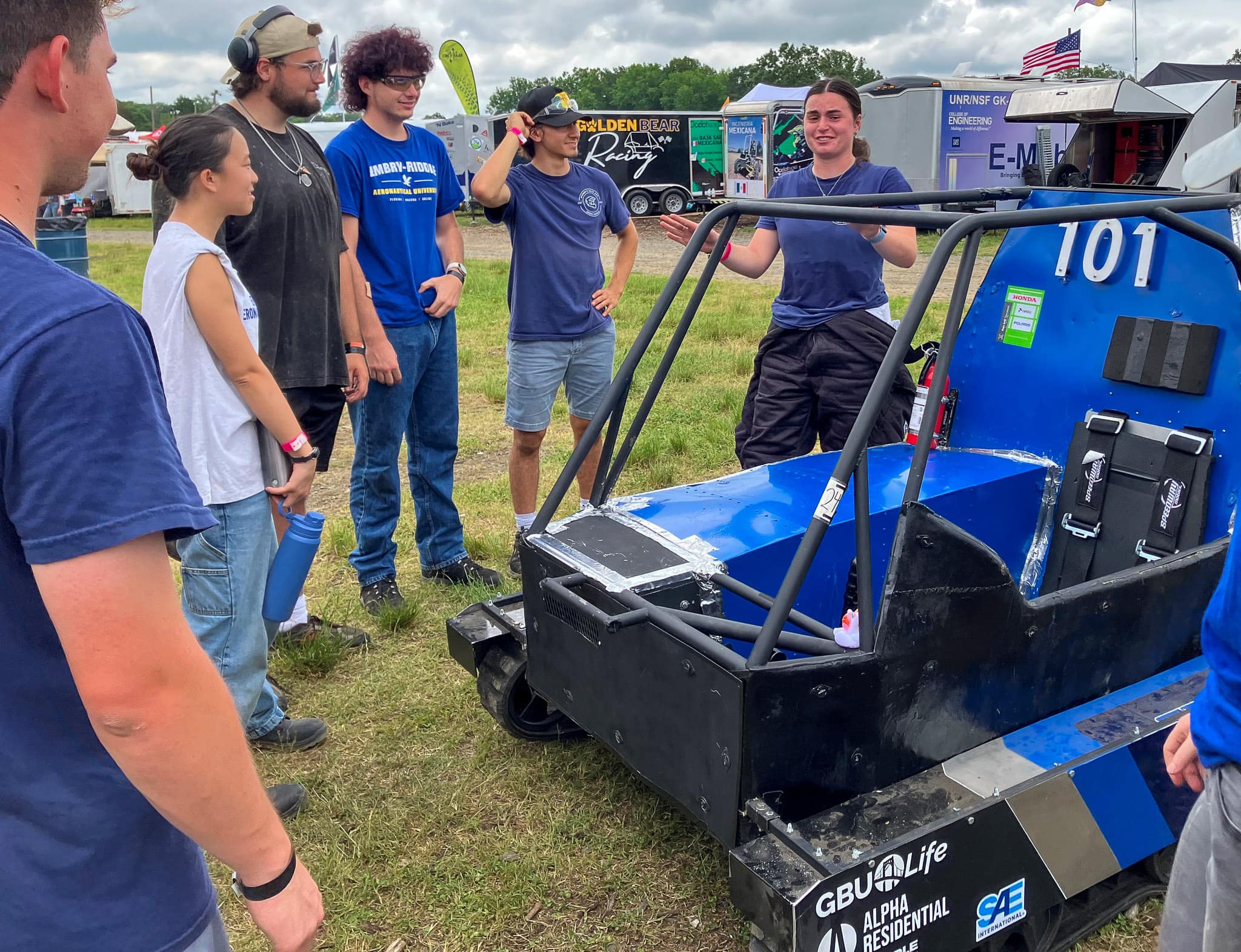 Woman talks to teammates at Baja SAE competition
