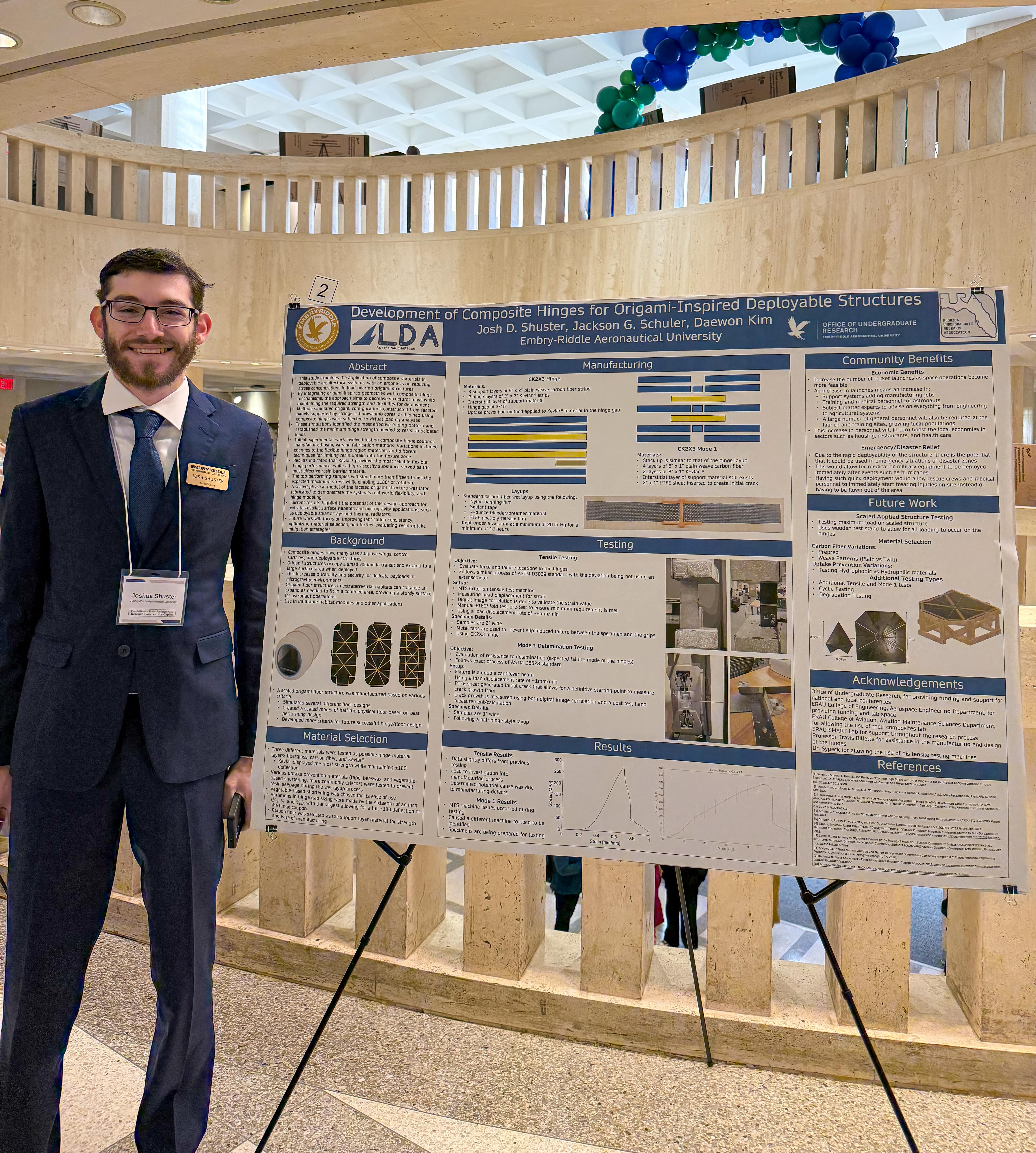 Joshua Shuster in front of poster