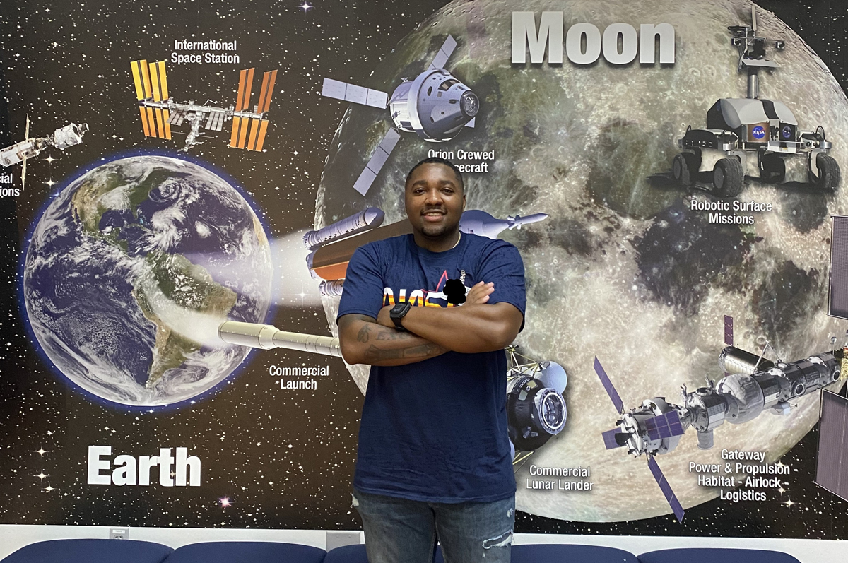 Man stands in front of picture of moon