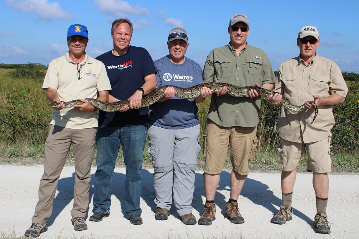 Researchers Joe Cerreta, Will Austin, Pete Miller, David Thirtyacre and Scott Burgess hold a live, 10-foot-long female Burmese python.