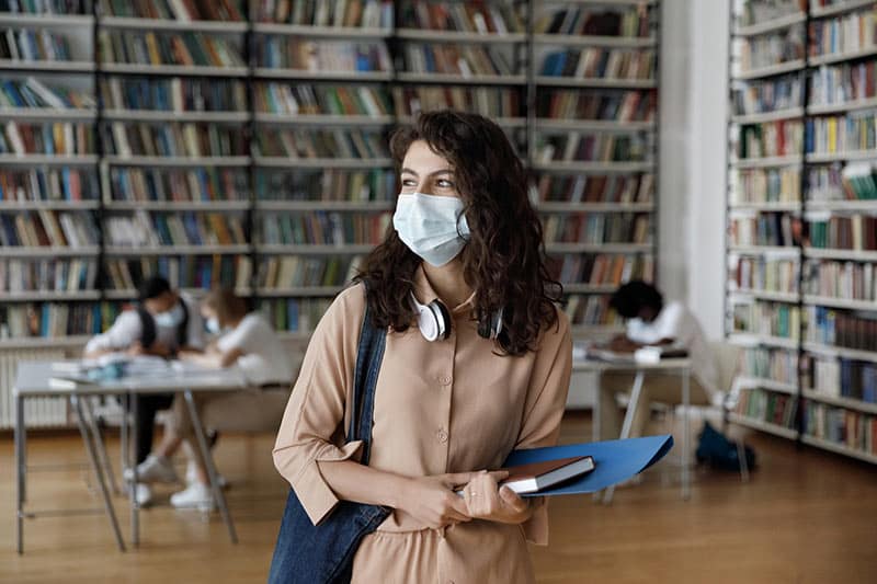 Woman wears mask in the library