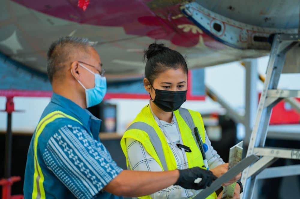 Two Hawaiian Airlines employees talking to each other