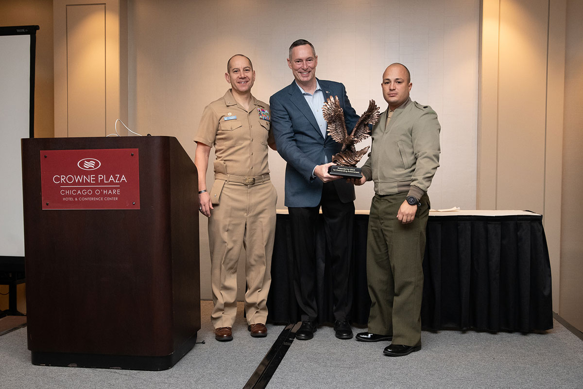 Embry-Riddle’s senior enlisted Marine staff member, Gunnery Sergeant Felix Arroyo Robles (right), USAA award presenter Michael Magnetta (center) and Embry-Riddle NROTC Commanding Officer Captain Carlos Medina (left).