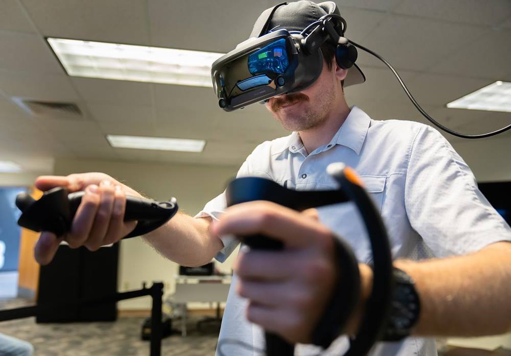 Embry-Riddle student Cody Hubbard, a junior Aeronautical Science major, runs through a virtual-reality simulation of a plane's preflight checklist at the Advanced Flight Simulation Center.