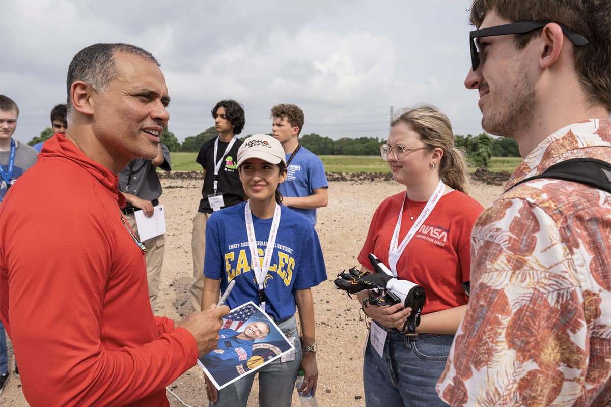 Embry-Riddle students show NASA astronaut Anil Menon (left) a spacesuit glove prototype that was part of their winning project at the NASA Artemis Student Challenge
