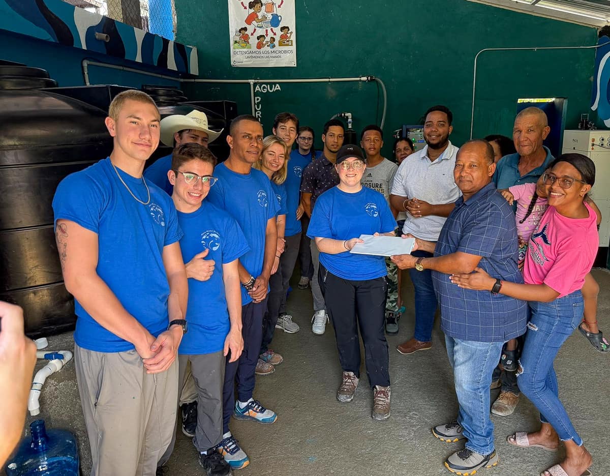 Pure Water Project president Megan Neumann hands residents the purifier user manual, with instructions in English and Spanish and all component datasheets.