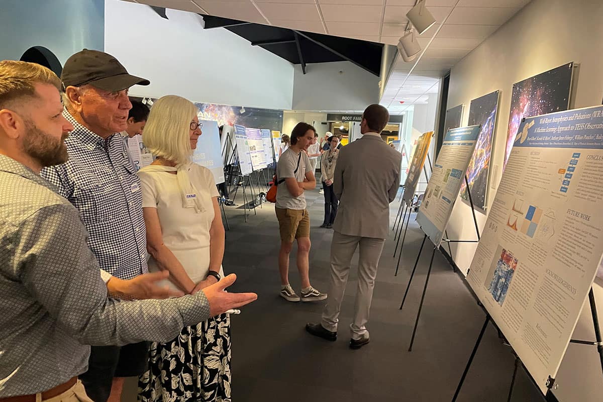 Worldwide Campus student Ryan Gilbert talks to event attendees about his research