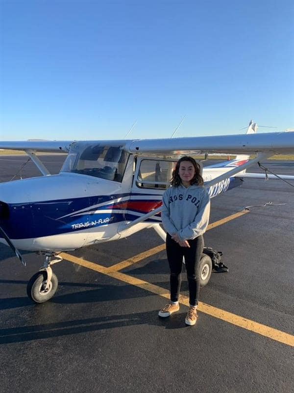 High school student stands with Cessna