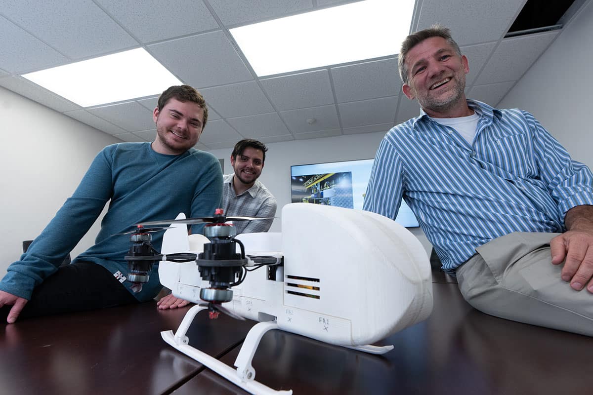 Ph.D. candidate Jackson Asiatico, master’s student Sebastian Lopez and Dr. Michael Kinzel pose with a prototype of the Dragonfly rotorcraft lander
