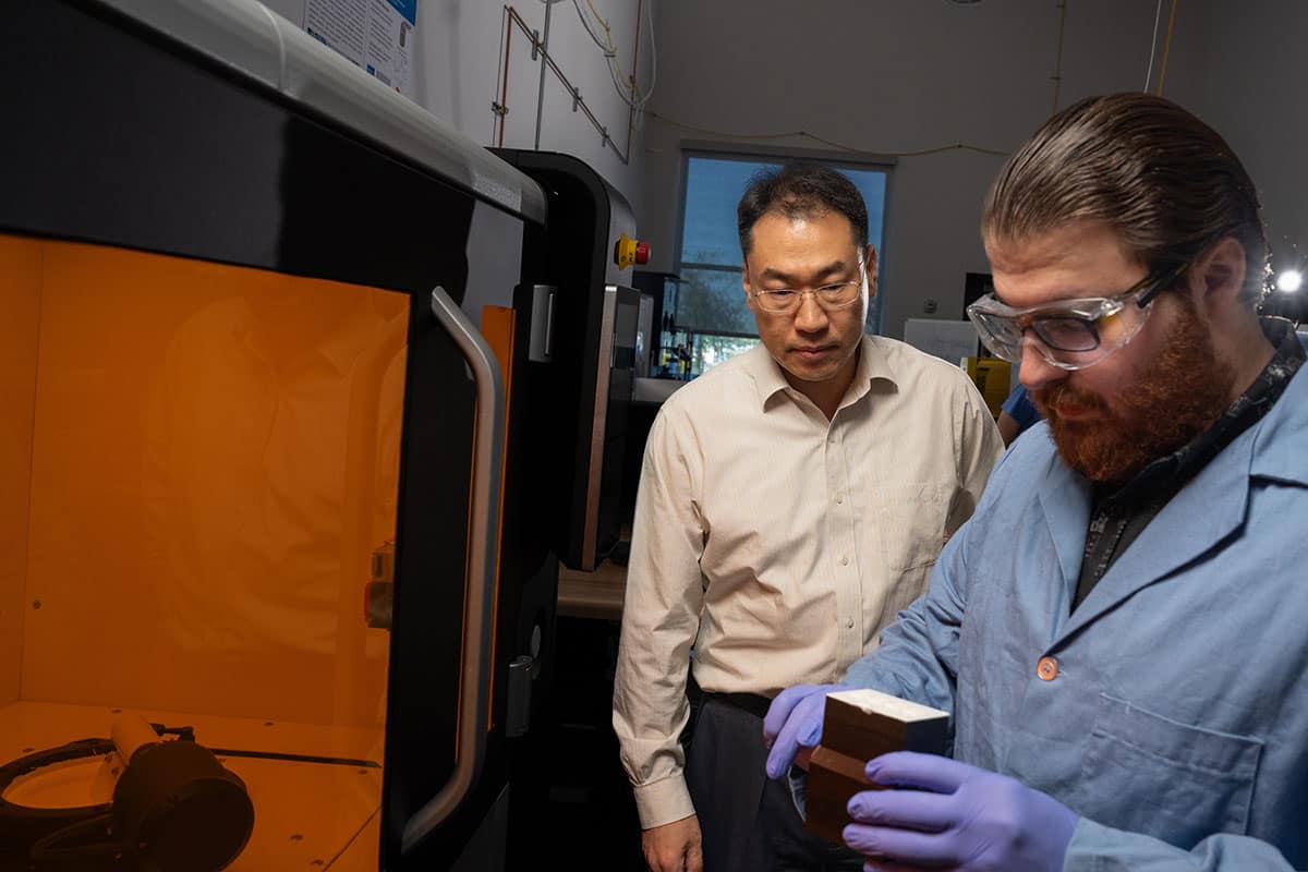Dr. Daewon Kim, professor of Aerospace Engineering, works with Embry-Riddle Ph.D. student Nicholas Reed at the Lithoz CeraFab Multi 2M30