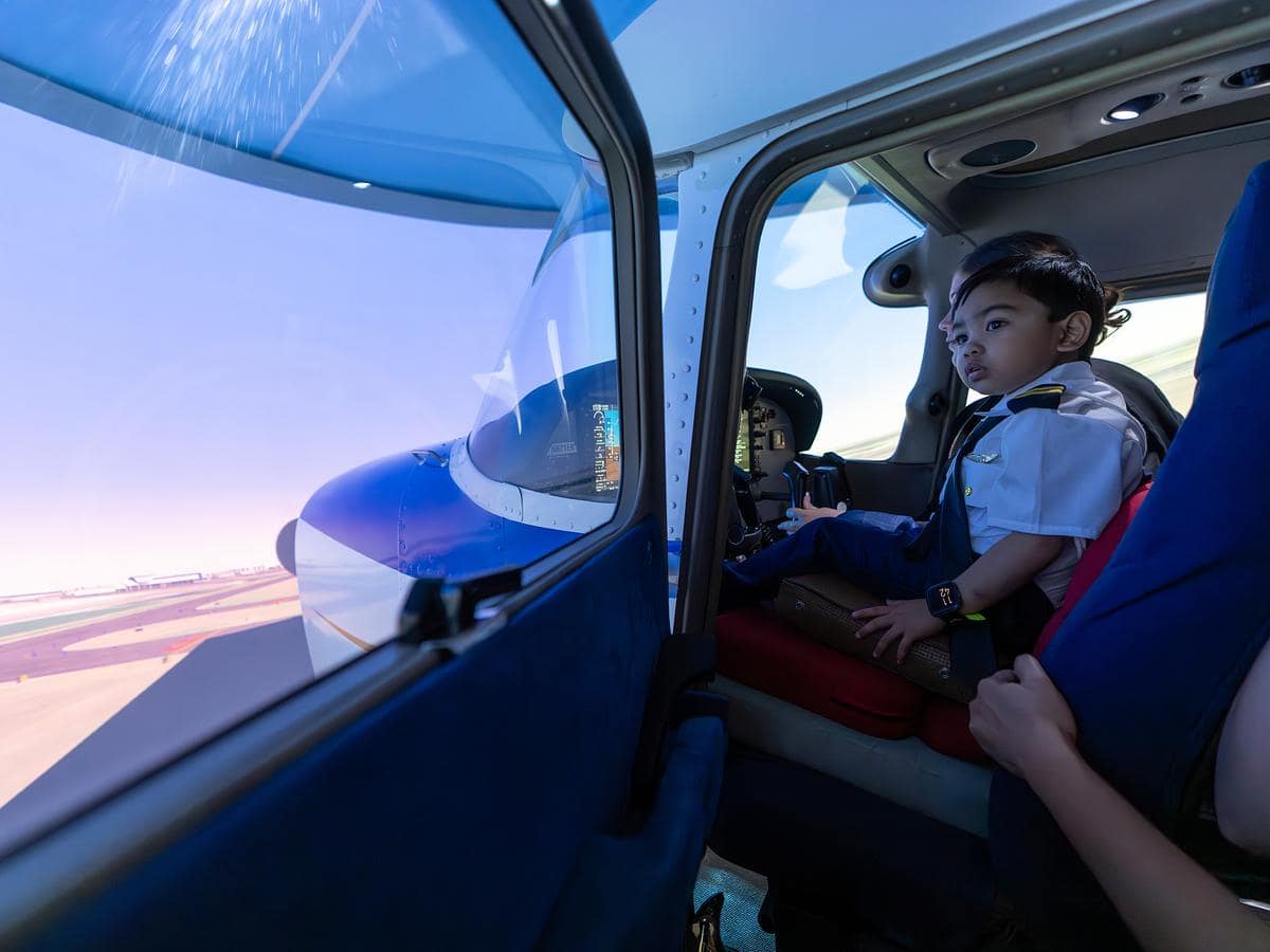 Kryzian, who loves aviation, sits in a Cessna 172 flight simulator.