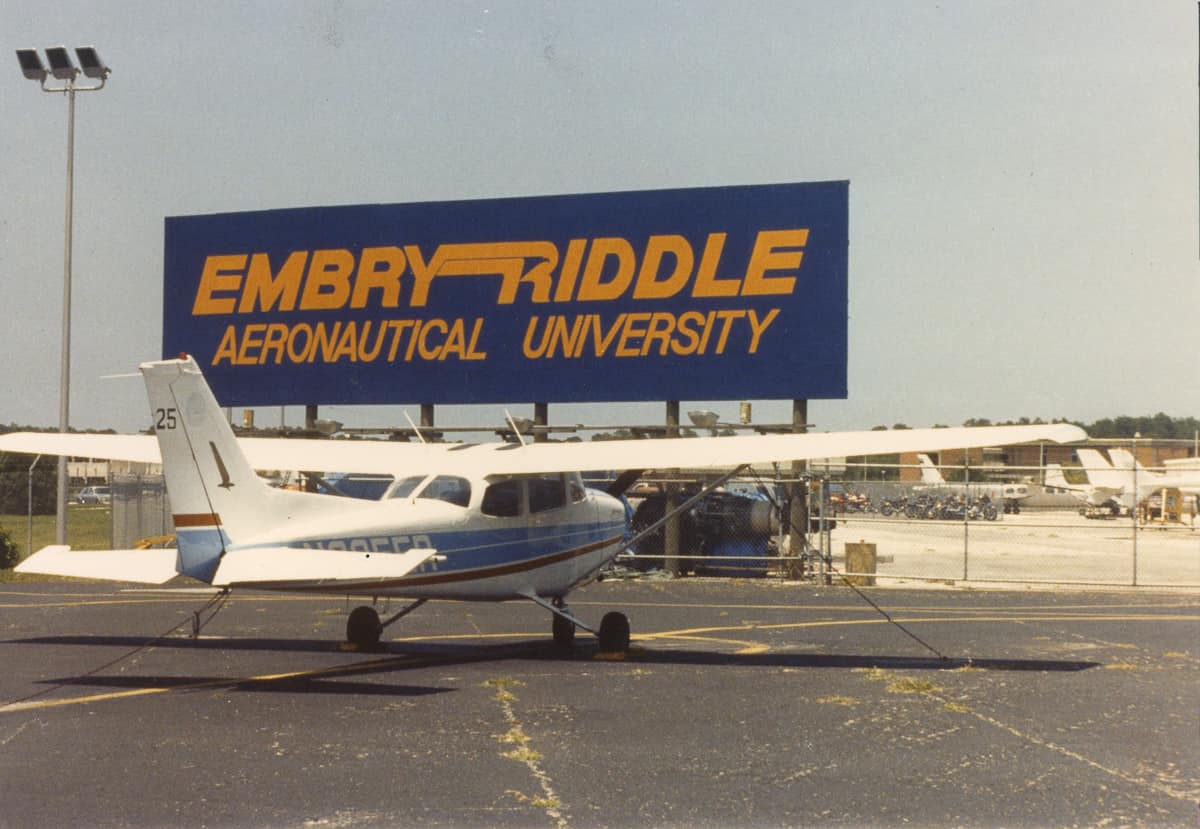 Cessna 172 on the flight line in front of Embry-Riddle sign in the 1980s