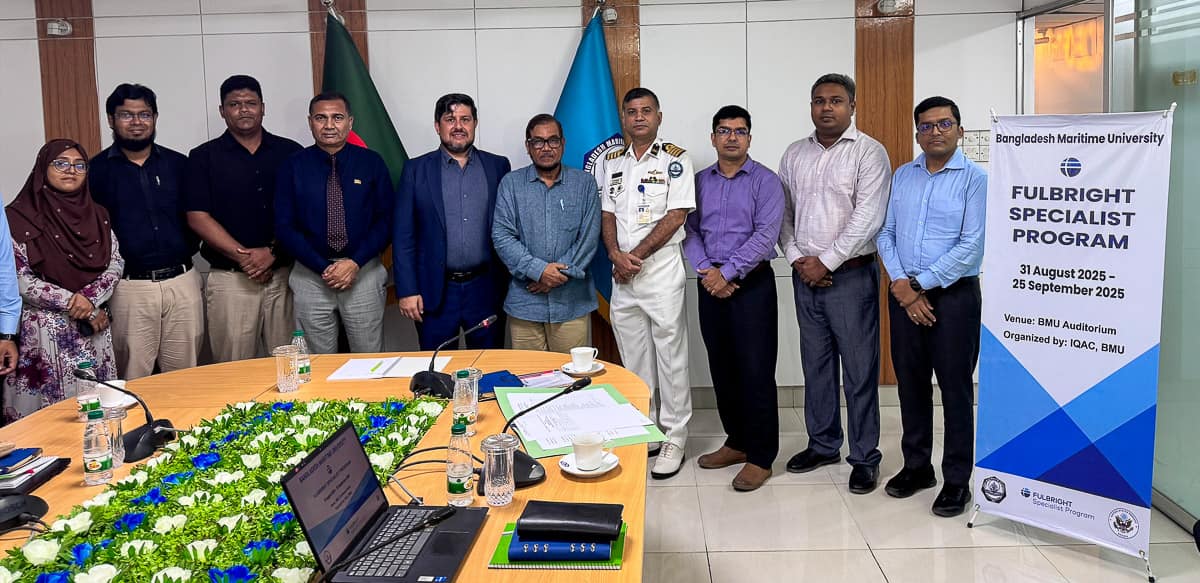 Dr. Burak Cankaya stands with others near a Fulbright sign at Bangladesh Maritime University (BMU)