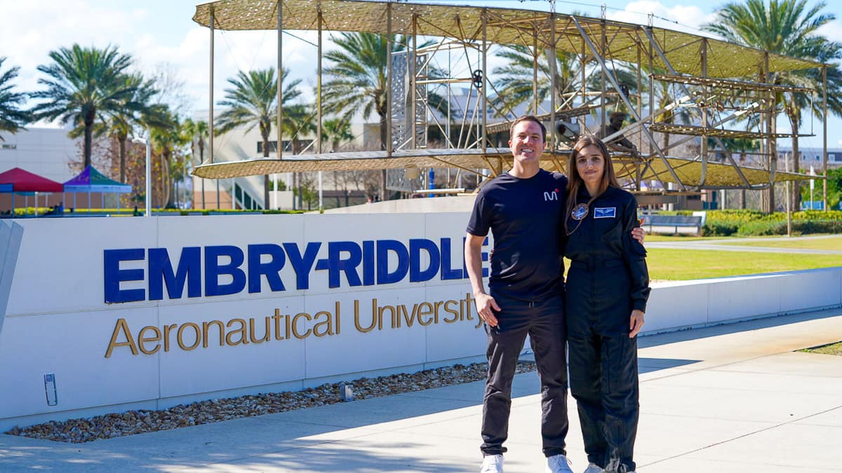 Embry-Riddle alumna Maria Noel de Castro Campos and her fiance, David, pose on campus in front of sign